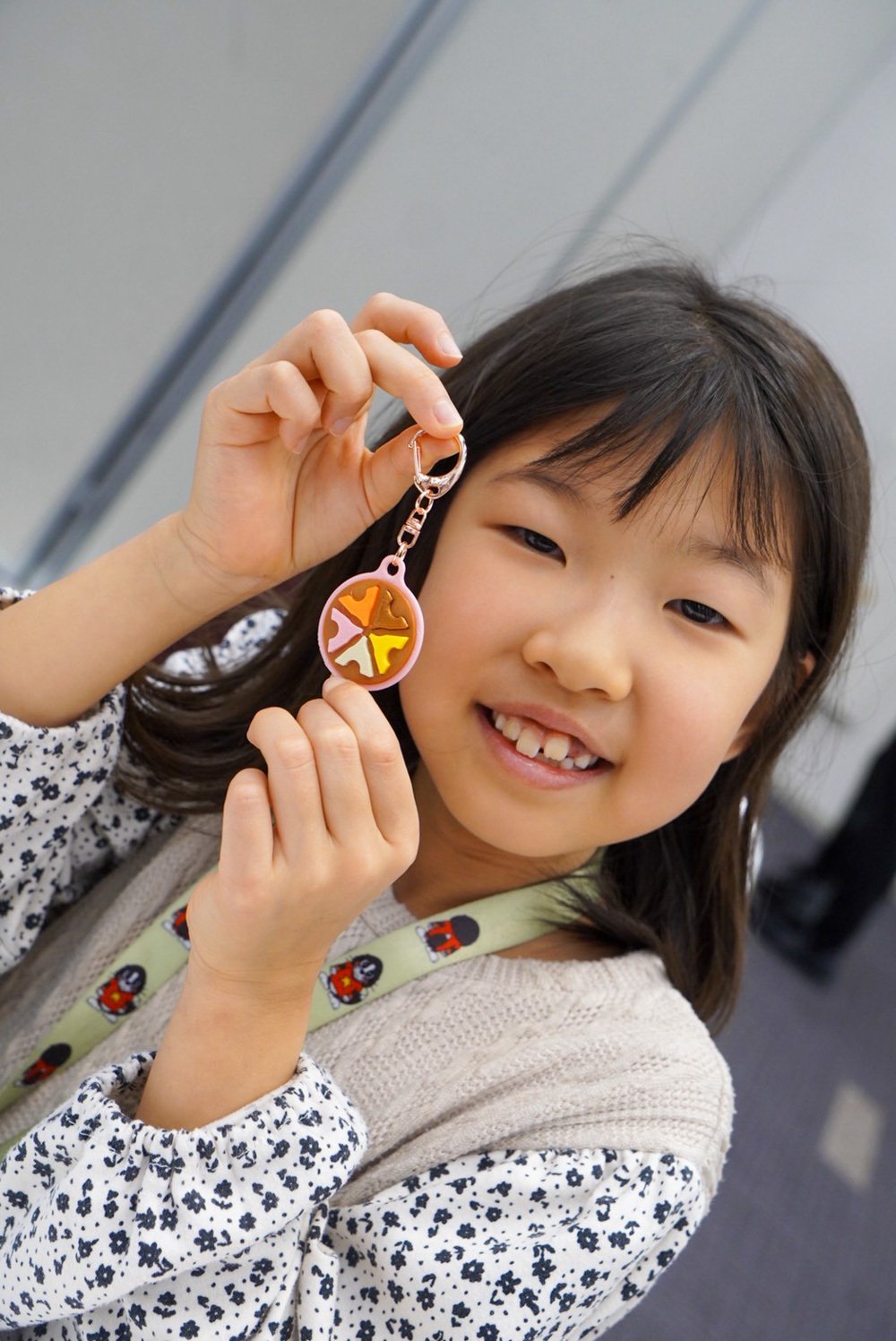 できあがったキーホルダーを持つ笑顔の子ども