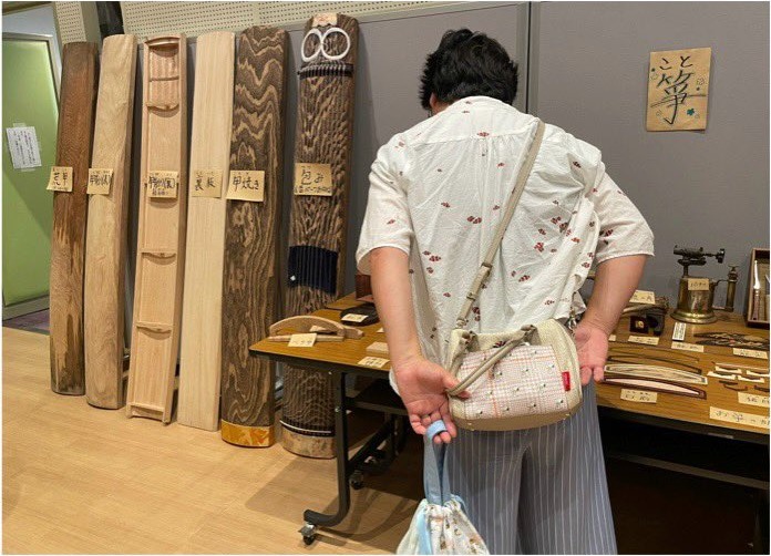 箏の材料となる木材の展示をご覧になる来場者